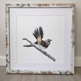 A framed bird drawing featuring a small brown and gray bird perched on a branch, set in a distressed white and beige rustic frame against a neutral wall and wood floor.