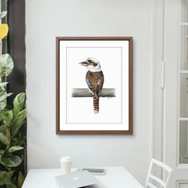 Framed artwork of a bird on a branch in a home office setting.