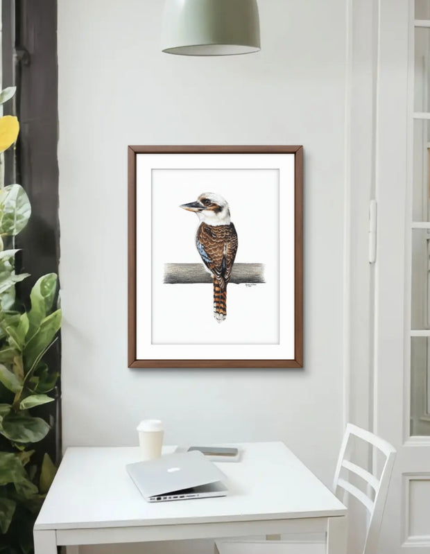 Framed artwork of a bird on a branch in a home office setting.