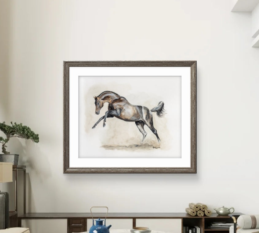 Framed artwork of a horse on a wall in a room with a desk and decor items.