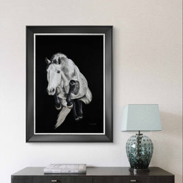 Framed black and white artwork of a horse head on a wall above a console table with a lamp.