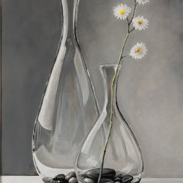 Two glass vases with stones and flowers on a gray background