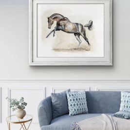 Framed artwork of a horse on a wall above a sofa in a living room.