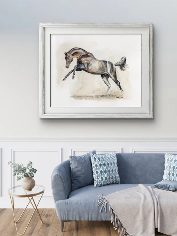 Framed artwork of a horse on a wall above a sofa in a living room.